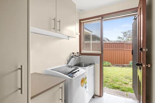 悉尼Beautiful Home In Milperra Sleeps 8的一个带水槽和洗碗机的厨房