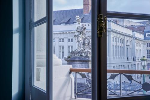 布鲁塞尔Juliana Hotel Brussels的雕像,从一扇窗户望向一座建筑