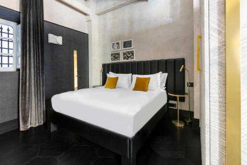 佛罗伦萨Numa Florence Goldoni的卧室配有一张带黄色枕头的大型白色床。
