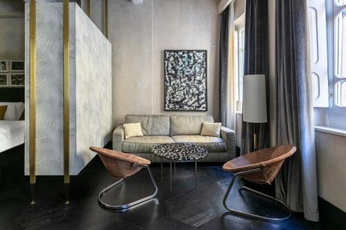 佛罗伦萨Numa Florence Goldoni的客厅配有沙发和两把椅子