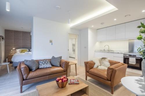 剑桥Luxury City Centre Apartment的一间带两张沙发的客厅和一间厨房