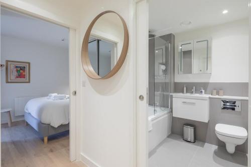 剑桥Luxury City Centre Apartment的浴室配有盥洗池、卫生间和镜子。