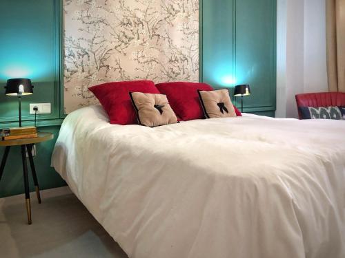 贝莱斯Casa Secreta Vélez-Málaga centro的卧室配有带红色枕头的白色床