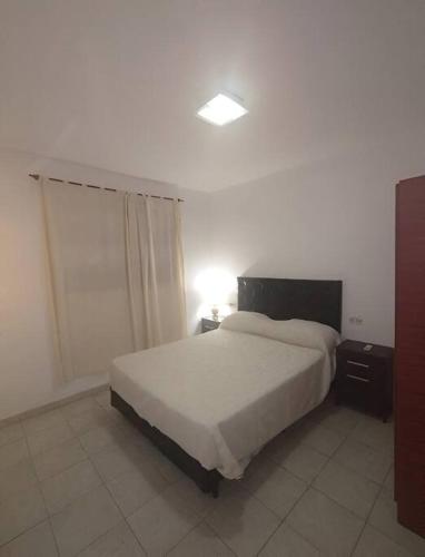 San Isidrodepartamento, valle viejo, catamarca的一间卧室配有一张床和一张桌子上的台灯