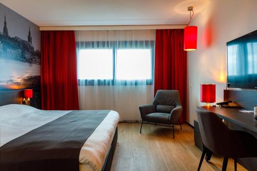 罗森达尔巴斯琛哥罗普酒店的酒店客房配有一张床、一张桌子和一把椅子。