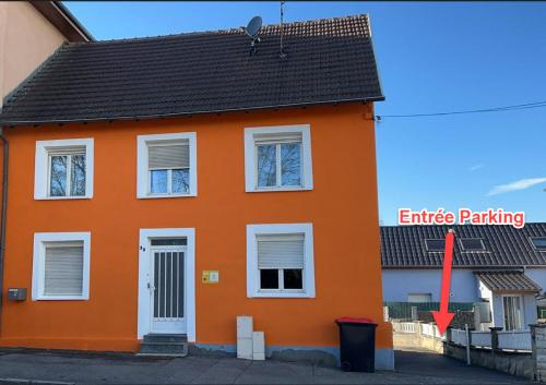 圣路易Chambre climatisée et cosy Auberge du manala Hôtel 24 24的橙色的房子,红色的箭头指向橙色的屋顶