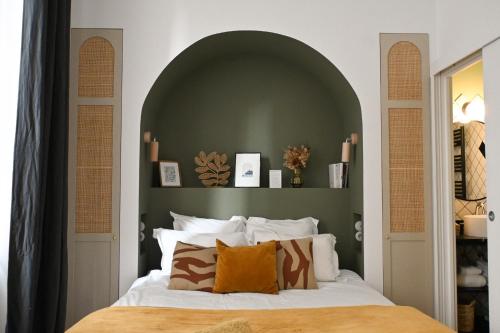 波尔多Maison Fernand B&B的一间卧室配有一张带绿色床头板的床