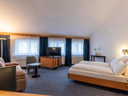 埃施韦勒B&B HOTEL Eschweiler的酒店客房,配有床和电视