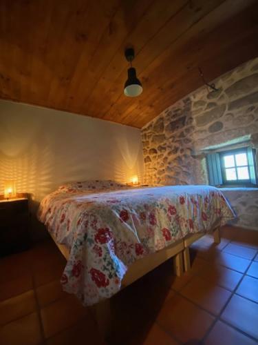 Três HorasQuinta Abelha的卧室配有一张石墙床