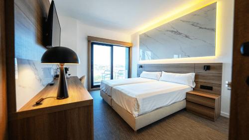 桑亨霍因芬尼特桑克森克索酒店的一间卧室设有一张大床和一个大窗户
