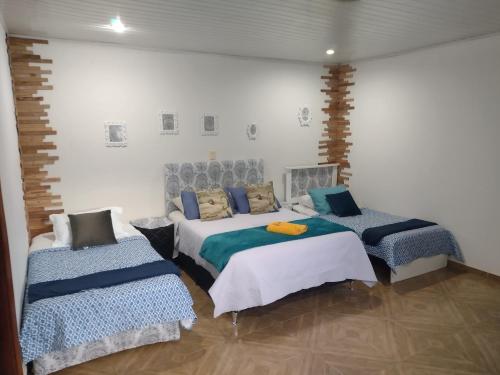 埃斯特城LVL Hospedaje Ejecutivo的一间卧室配有两张床和两把椅子