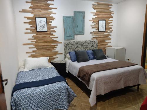 埃斯特城LVL Hospedaje Ejecutivo的卧室配有两张床,墙上挂有两张照片
