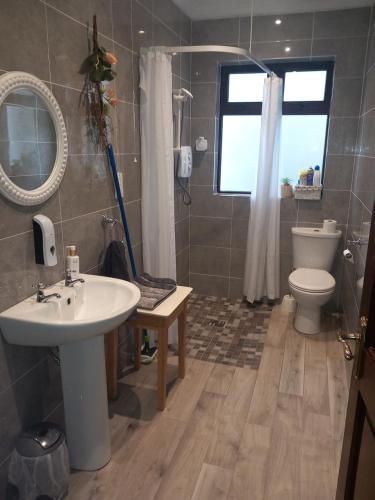 卡斯莱兰Home Comforts的一间带水槽和卫生间的浴室以及窗户。