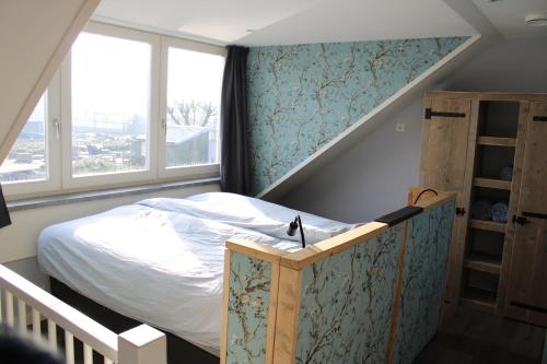 德克瓦克Huis over de dijk的一间小卧室,配有一张床和一个楼梯
