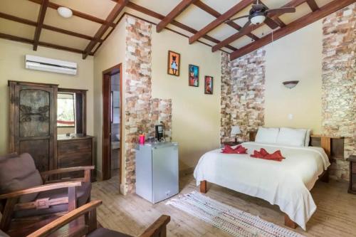 卡维塔Casa Caribbean Coconut的卧室配有一张白色的大床和石墙