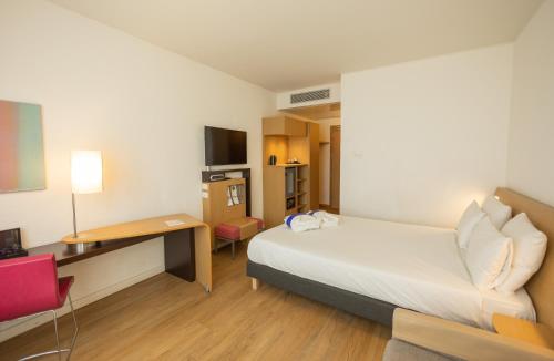 萨莱诺诺富特萨雷诺伊斯特雷其酒店的小酒店客房配有一张床和一张书桌