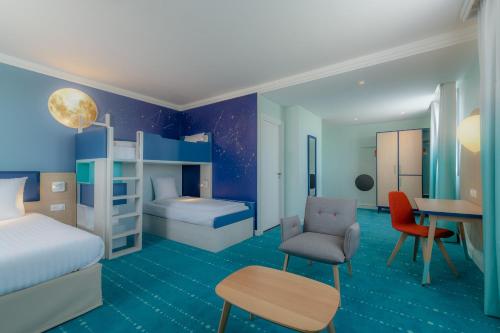 马尼库尔勒翁格尔Grand Magic Hotel Marne La Vallée的客房设有带一张床和一张书桌的卧室。