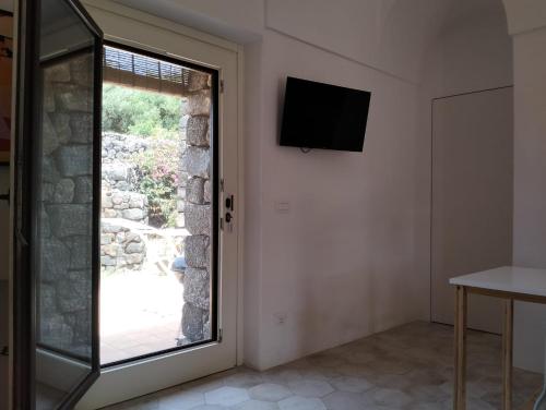 潘泰莱里亚Dammusielenas的一间设有窗户和墙上电视的房间