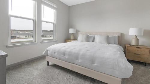 MiddleburgLanding Modern Apartment with Amazing Amenities (ID1239X542)的白色卧室设有一张大床和两个窗户