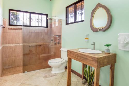 瓜纳卡斯特Villa Roble Alto的浴室配有卫生间、盥洗盆和淋浴。