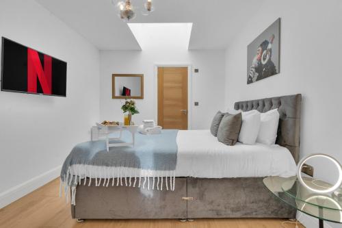 伦敦homely - West London Apartments Putney的一间卧室配有一张大床和一张桌子