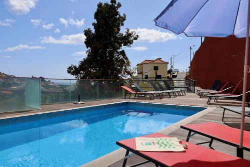 卡马拉-德洛布什Villas Quinta da Lapa by AnaLodges的一个带两把椅子和遮阳伞的游泳池