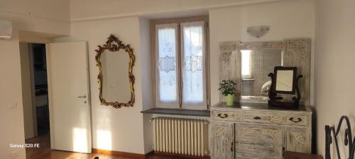 诺维利古雷Il giardino di Marianna的客房设有带镜子的梳妆台和窗户。