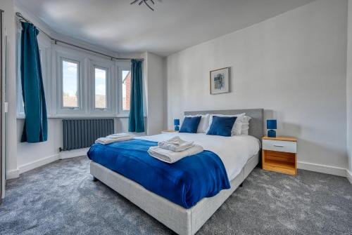 牛津Aryas Homes Oxford - Headington的一间卧室配有一张带蓝色床单的大床
