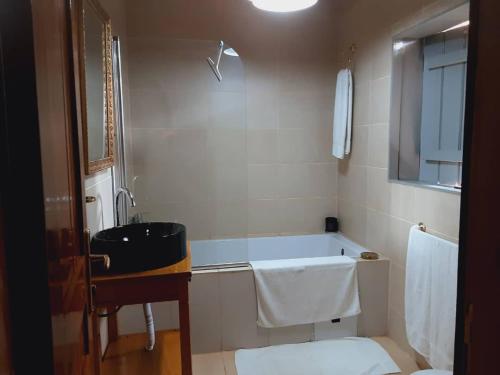 雅温得Village NDJIKESSI的带浴缸和盥洗盆的浴室