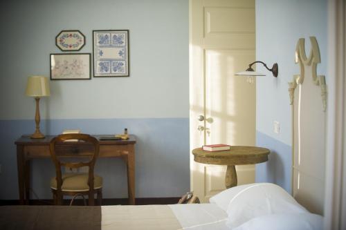 阿尔巴·阿德里亚蒂卡维拉圣安杰洛别墅的一间卧室配有书桌、一张床和一把椅子