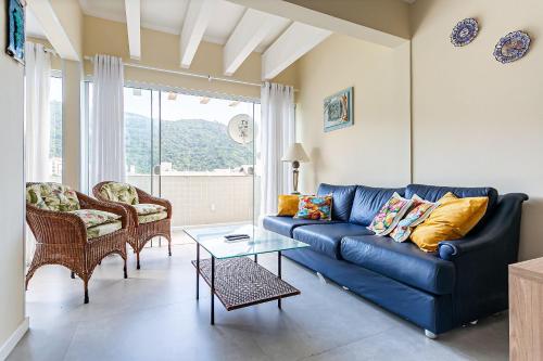 弗洛里亚诺波利斯Apto vista mar a poucos metros da P. Brava CTA022的客厅配有一张蓝色的沙发,配有一张桌子