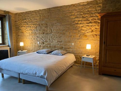 泰朗库尔费泽尔埃尚布尔酒店的一间卧室配有一张床和两张带台灯的桌子。