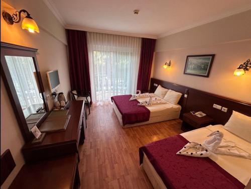 安塔利亚STELLA HOTEL&Spa ALL INCLUSIVE的酒店客房配有两张床和一张书桌