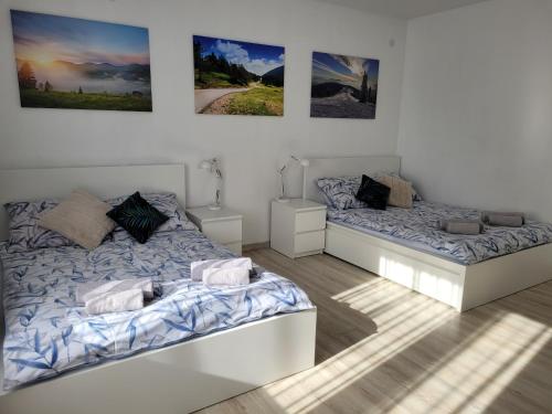 文盖尔斯卡－古尔卡Apartament BESKIDLOVE的卧室配有两张床,墙上挂有图片