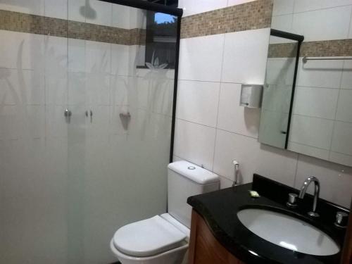 Nova Santa MedianeiraPousada Paraíso das Orquídeas的一间带卫生间、水槽和镜子的浴室