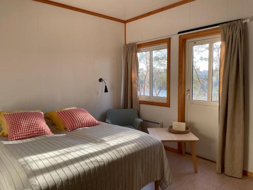 AkkerhaugenNorsjøtunet的卧室配有床、椅子和窗户。