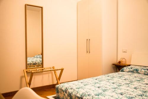 阿尔本加Villa Essenza - Rooms and Breakfast的一间卧室配有一张床和镜子