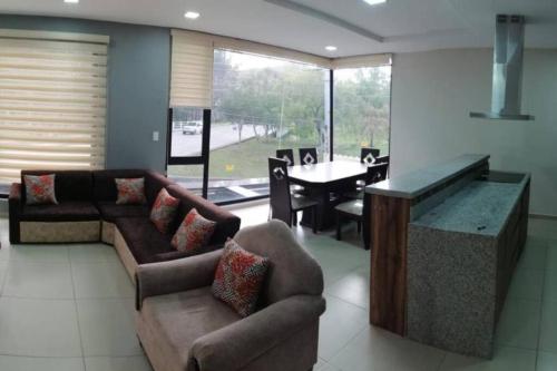 昆卡Departamento Acogedor: Nuevo y Amplio的带沙发的客厅和带桌子的用餐室