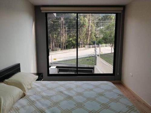 昆卡Departamento Acogedor: Nuevo y Amplio的卧室设有大窗户,享有街景