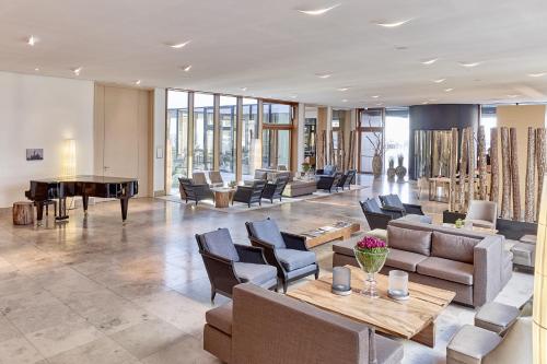 赫尔努姆BUDERSAND Hotel - Golf & Spa - Sylt的大堂配有沙发和乒乓球桌