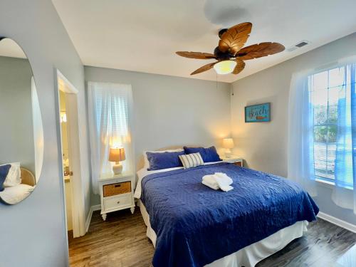 默特尔比奇Tee Time的一间卧室配有一张蓝色的床和吊扇