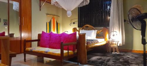 坎帕拉Aivilo Home的客厅配有带粉红色枕头的椅子