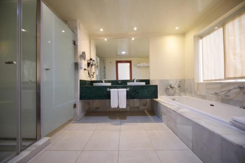 拉纳韦贝Bahia Principe Luxury Runaway Bay - Adults Only All Inclusive的带浴缸、两个盥洗盆和淋浴的浴室。
