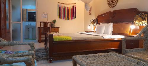 坎帕拉Aivilo Home的一间卧室配有一张大型木床和椅子
