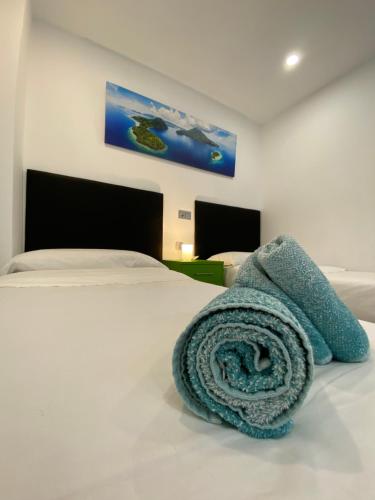 马略卡岛帕尔马Beach apartment Palma Center的一张白色的床,上面有蓝色的毯子