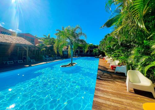 德赛Tropicana Suites的一个带棕榈树和躺椅的游泳池