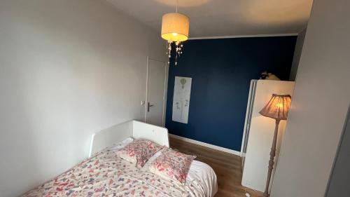 科隆布Le relais des JO 2024的一间卧室设有一张床和蓝色的墙壁
