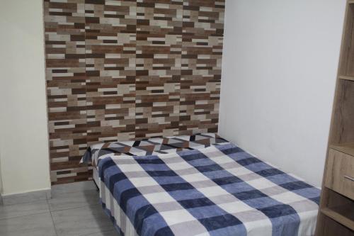 基布多APARTAMENTO CESAR CONTO的一张位于带 ⁇ 形墙的房间里的床