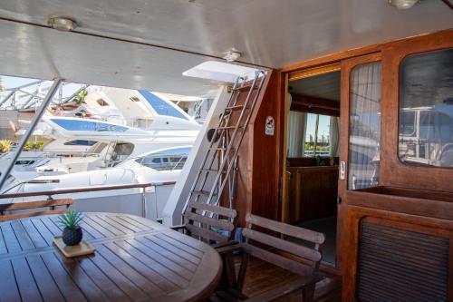 巴塞罗那Boat ALOHA的船上的木桌和椅子,带梯子