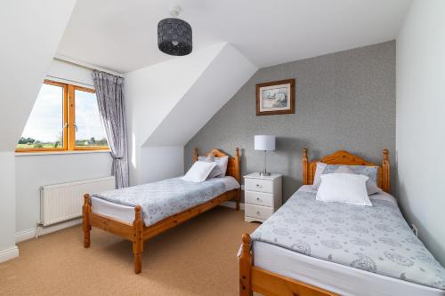 TermonbarryShannonside - Stylish 5 Bed Marina home & 40ft mooring的一间卧室设有两张床和窗户。